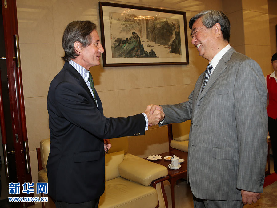Li Congjun (R), President of China's Xinhua News Agency, shakes hands with Peter Launsky-Tieffenthal, UN Under-Secretary-General for Communications and Public Information in Beijing, June 27, 2013. (Xinhua)