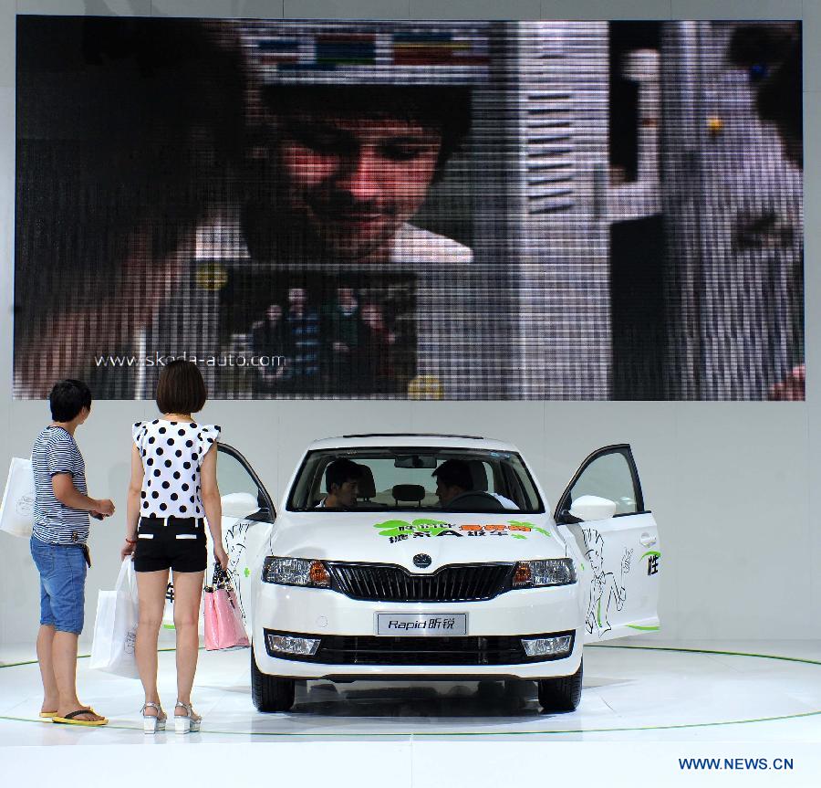 Visitors view a vehicle at the 12th Shenyang International Automobile Industry Expo in Shenyang, capital of northeast China's Liaoning Province, June 27, 2013. (Xinhua/Pan Yulong)