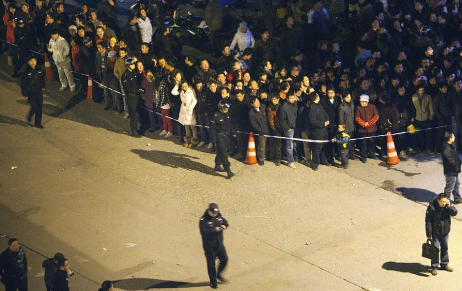 A crowd of people stands on the street after a nearby bank exploded at Wuhan, Dec. 1, 2012. (Photo/CNTV)