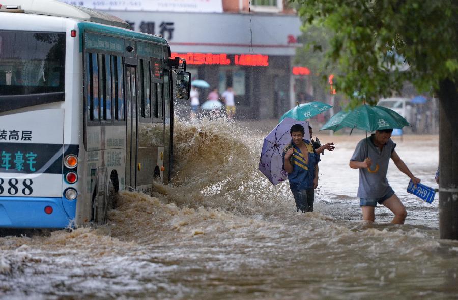 Pedestrians avoid water sprayed by a bus on a flooded road in Nanchang, capital of east China's Jiangxi Province, June 28, 2013. Heavy rainfall hit the city on Friday. (Xinhua/Zhou Mi) 