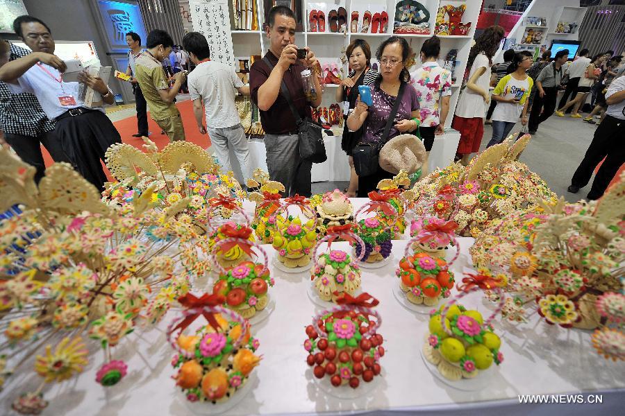 Visitors look at traditional buns of various shapes during the 1st Shanxi Cultural Industry Expo in Taiyuan, capital of north China's Shanxi Province, June 29, 2013. The exhibition will last till July 3. (Xinhua/Zhan Yan)  