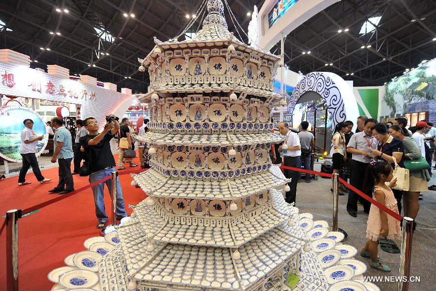 Visitors look at a ceramic pagoda during the 1st Shanxi Cultural Industry Expo in Taiyuan, capital of north China's Shanxi Province, June 29, 2013. The exhibition will last till July 3. (Xinhua/Zhan Yan) 
