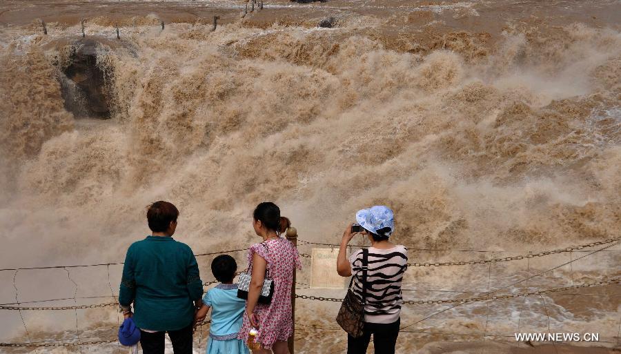People gather to watch the Hukou Waterfall of the Yellow River in Jixian County, north China's Shanxi Province, June 30, 2013. (Xinhua/Lv Guiming) 