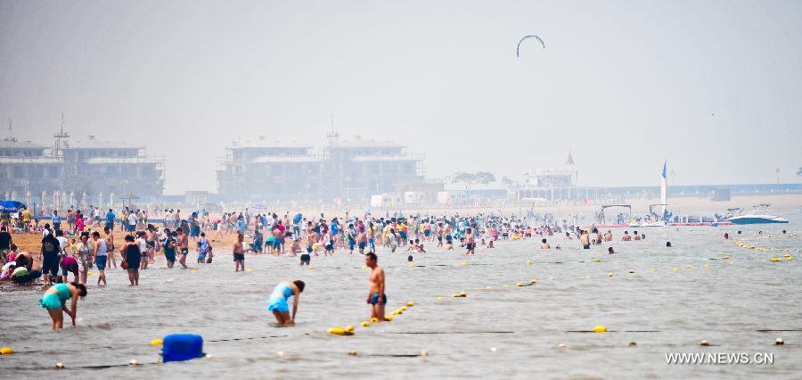 People swarm on the bathing beach in Dongjiangwan of north China's Tianjin Municipality, June 30, 2013. Many people came to Dongjiangwan to spend their weekends. (Xinhua/Zhang Chaoqun)