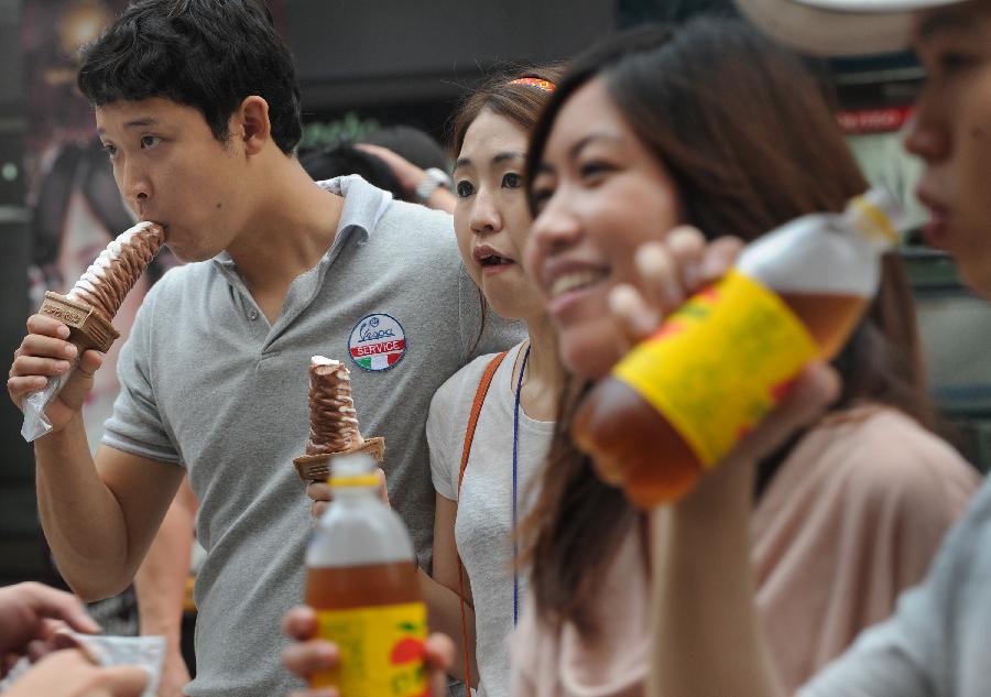 People eat ice creams and drink cold drinks in Taipei, southeast China's Taiwan, June 30, 2013. Taiwan's weather bureau announced Sunday that the average temperature in this June has reached 29 Celsius degree, a record high since Taipei weather station was established in 1896. (Xinhua/Tao Ming)