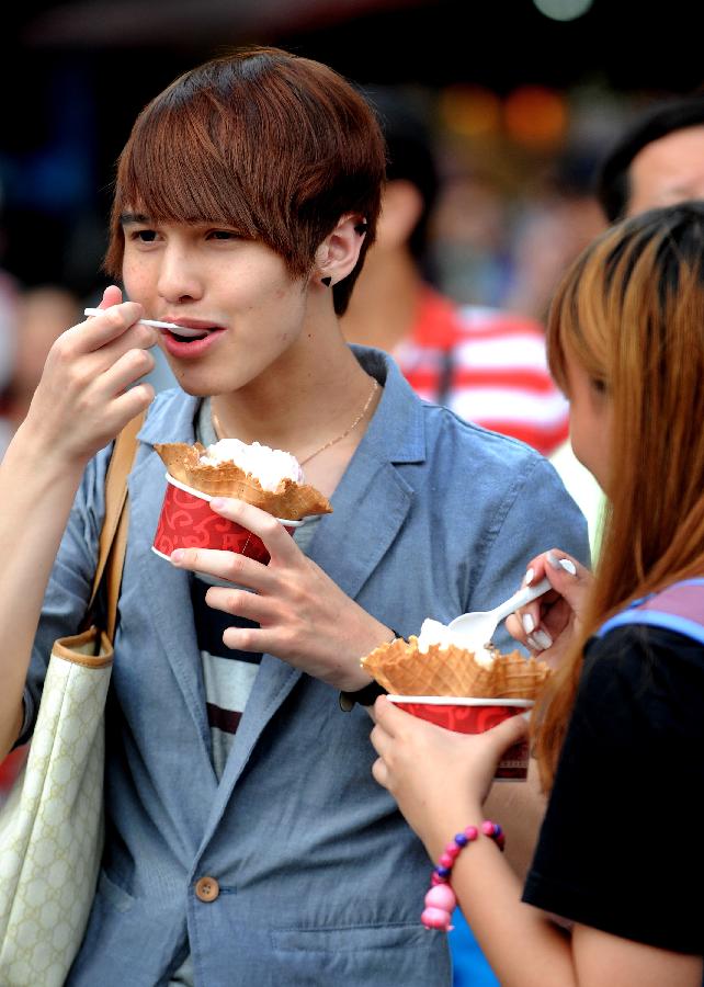 People eat ice creams in Taipei, southeast China's Taiwan, June 30, 2013. Taiwan's weather bureau announced Sunday that the average temperature in this June has reached 29 Celsius degree, a record high since Taipei weather station was established in 1896. (Xinhua/Tao Ming)