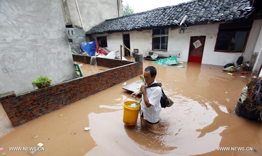 A villager is seen on a waterlogged road at Shaoyun Township in Tongliang County of Chongqing, southwest China, July 1, 2013. Rainstorms swept the county on Sunday and Monday, waterlogging roads and houses. (Xinhua/Tang Mingbing) 