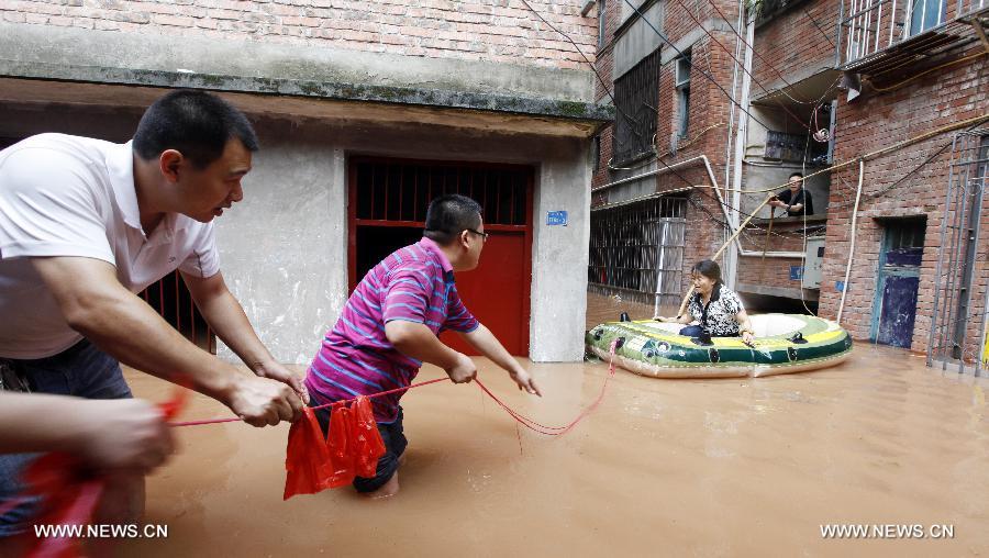 People rescue a trapped villager on waterlogged road at Shaoyun Township in Tongliang County of Chongqing, southwest China, July 1, 2013. Rainstorms swept the county on Sunday and Monday, waterlogging roads and houses. (Xinhua/Tang Mingbing) 