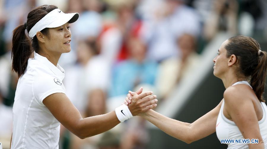 Li Na (L) of China shakes hands with Roberta Vinci of Italy after their fourth round women's singles match on day 7 of the Wimbledon Lawn Tennis Championships at the All England Lawn Tennis and Croquet Club in London, Britain on July 1, 2013. Li Na won 2-0. (Xinhua/Wang Lili)