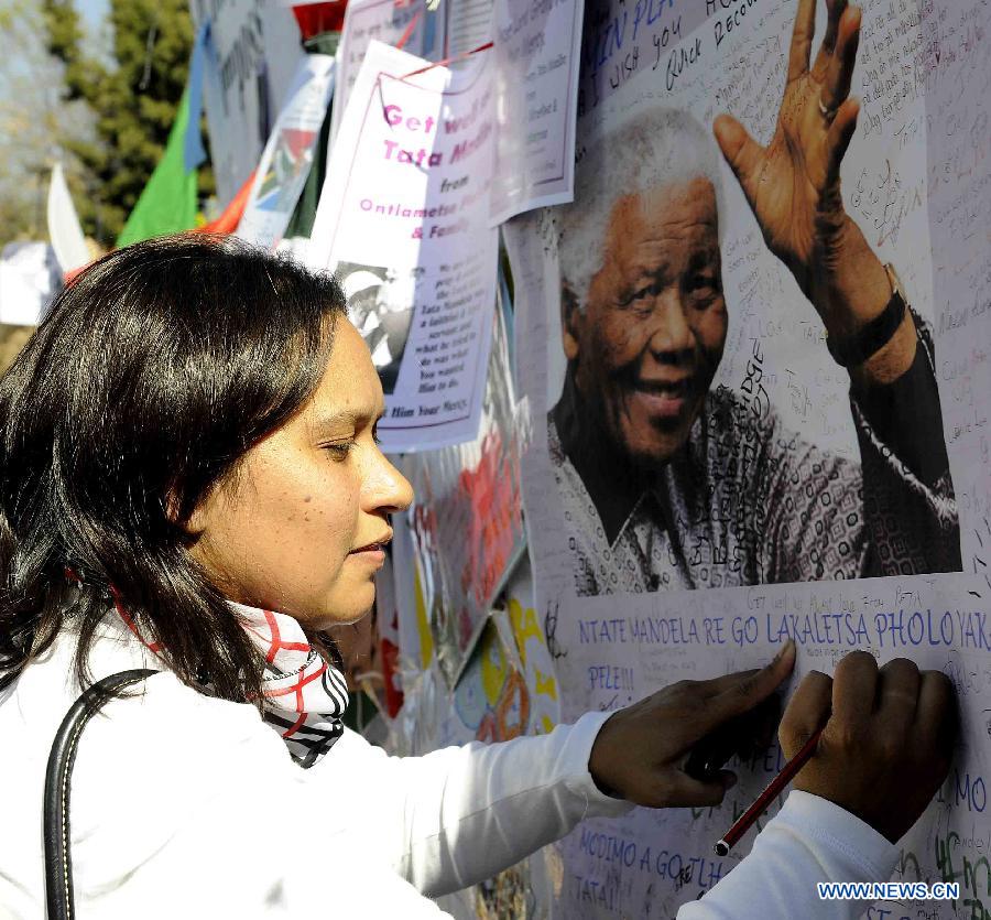 A local resident writes her wishes outside the hospital where South Africa's anti-apartheid icon Nelson Mandela is treated in Pretoria, South Africa, to pray for Mandela, July 1, 2013. (Xinhua/Li Qihua) 