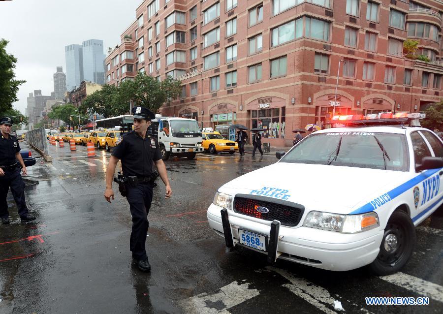 A police officer gurads at the crime scene in New York, the United States, on July 1, 2013. The male victim, a 56-year-old construction worker, was shot in the chest on West 49th Street and Ninth Avenue around 9 a.m. The victim was taken to Roosevelt Hospital. The suspect, believed to be an ex-employee of the same construction compnay, fled the scene in a white vehicle. He is considered armed and dangerous, according to the police. (Xinhua/Wang Lei)