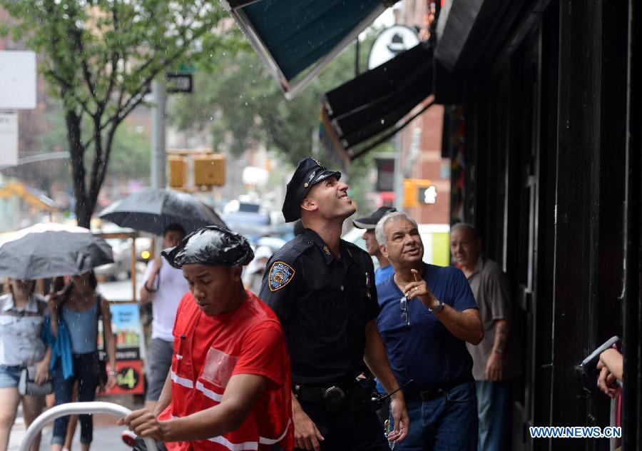 A police officer investigates at the crime scene in New York, the United States, on July 1, 2013. The male victim, a 56-year-old construction worker, was shot in the chest on West 49th Street and Ninth Avenue around 9 a.m. The victim was taken to Roosevelt Hospital. The suspect, believed to be an ex-employee of the same construction compnay, fled the scene in a white vehicle. He is considered armed and dangerous, according to the police. (Xinhua/Wang Lei)