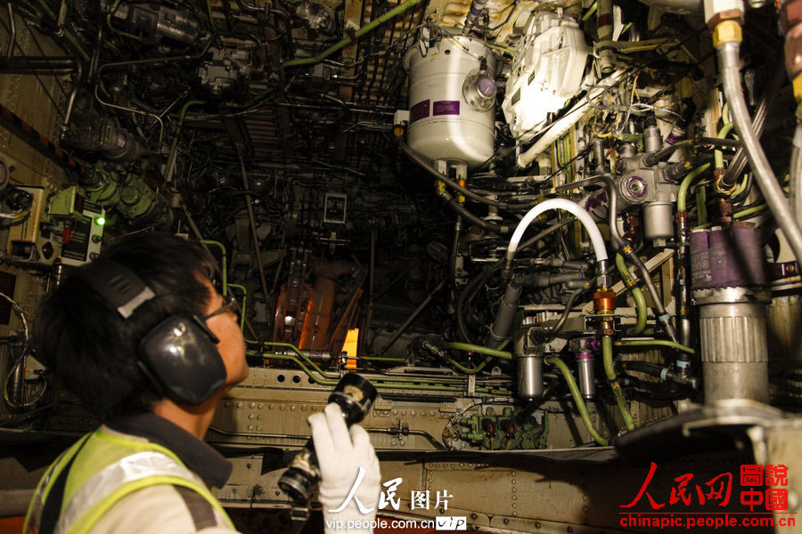 Wang Jin climbs into the cabin to check the engine's working condition. (Photo:Wang Yu/vip.people.com.cn)