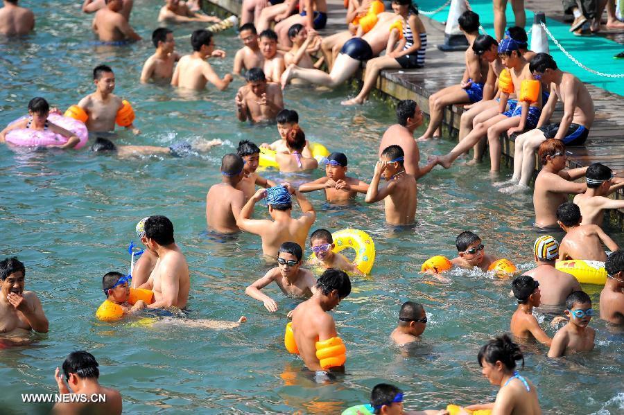 Citizens enjoy coolness at an outdoor bathing place in Jinan, capital of east China's Shandong Province, July 3, 2013. The highest temperature in Jinan reached 38 degrees celsius on Wednesday. (Xinhua/Guo Xulei)