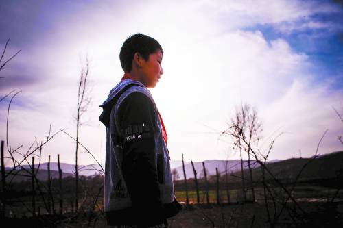 Yang Yongjie, a sixth-grade student, walks on the way home. He was good in study and would probably continue his study in a better school in the county. (Photo/China Youth Daily)