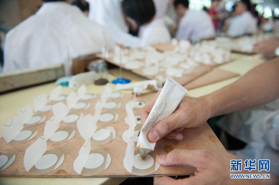 A doctor prepares plaster applications at the Guangdong Provincial Traditional Chinese Medical Hospital July 3, 2013. According to traditional Chinese medicine, winter illnesses such as chronic bronchitis and rheumatic arthritis can be prevented by applying plaster medicine on certain acupuncture points on the back during the hottest days of the year. Three applications, called "hot summer days plaster medicine" literally in Chinese, should be used respectively every 10 days around the time between the Lesser Heat and the Great Heat, usually between mid or late July to early August. (Photo: Mao Siqian/Xinhua)