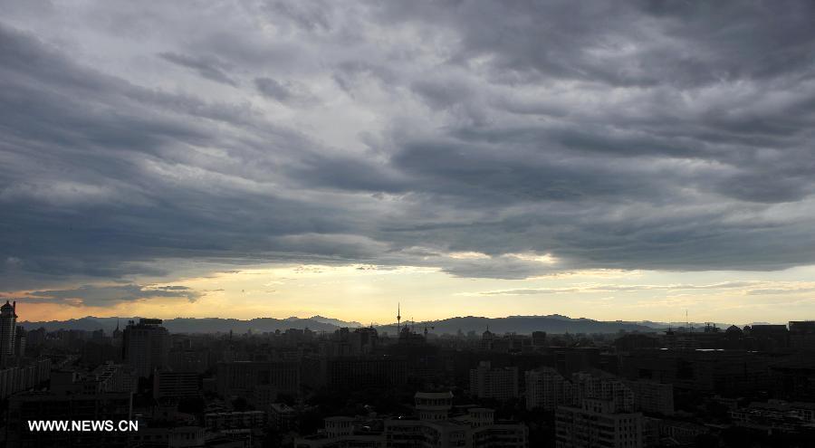 Photo taken on July 4, 2013 shows the sunset glow and the dark clouds in Beijing, capital of China. Beijing witnessed a shower at the dusk on Thursday. (Xinhua/Chen Yehua)  
