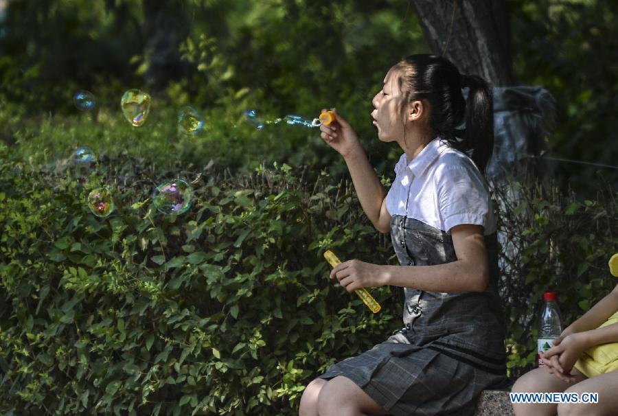 A girl blows bubbles in a park in Urumqi, capital of northwest China's Xinjiang Uygur Autonomous Region, July 5, 2013. Some 450,000 pupils and middle school students have started their summer vacation recently. With less homework assigned by the school, they are able to enjoy a relaxing vacation this summer. (Xinhua/Wang Fei)
