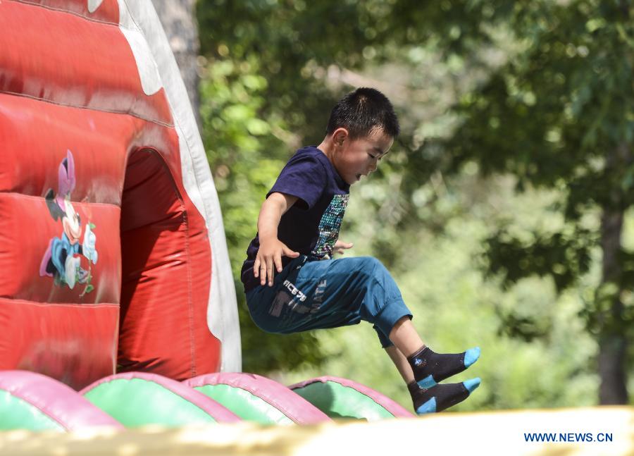 A boy plays in a park in Urumqi, capital of northwest China's Xinjiang Uygur Autonomous Region, July 5, 2013. Some 450,000 pupils and middle school students have started their summer vacation recently. With less homework assigned by the school, they are able to enjoy a relaxing vacation this summer. (Xinhua/Wang Fei) 