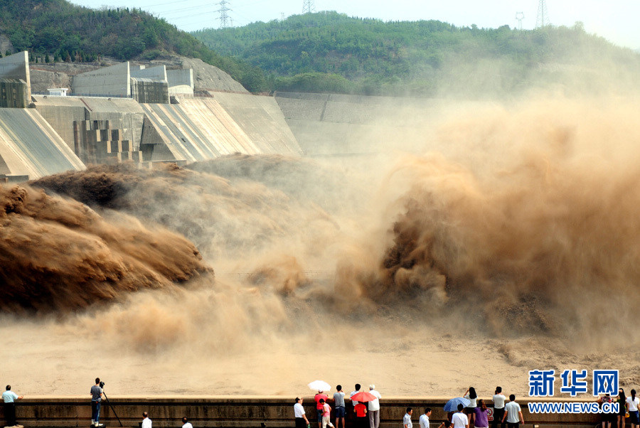 Tourists watch water gushing out from the Xiaolangdi Reservoir on the Yellow River during a sand-washing operation in Luoyang, central China's Henan Province, July 5, 2013. (Xinhua/Miao Qiu Nao)