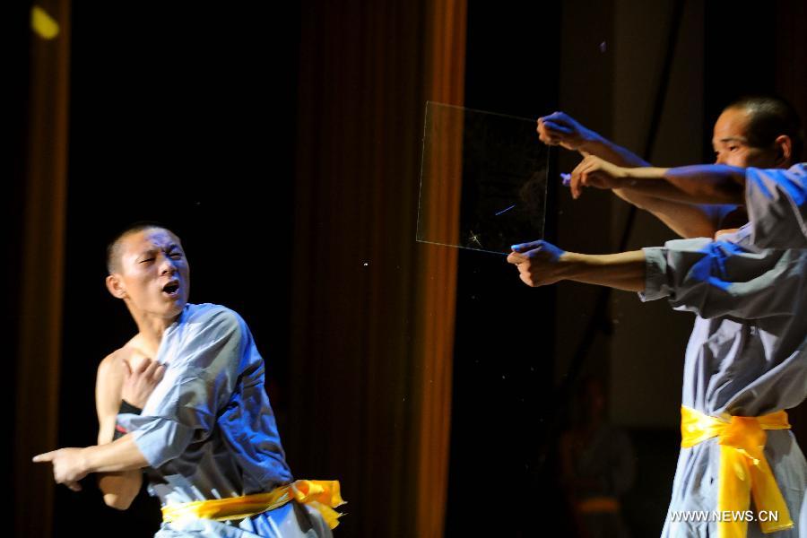 Performers of the Yandong Shaolin Kungfu troupe perform piercing the glass with needles at the Worker's Cultural Palace, Taiyuan, capital of north China's Shanxi Province, July 6, 2013. The martial art troupe have their performers trained in the renowned Shaolin Temple, and staged performances worldwide in the hope of promoting Shaolin-style martial arts and Chinese culture. (Xinhua/Fan Minda)  