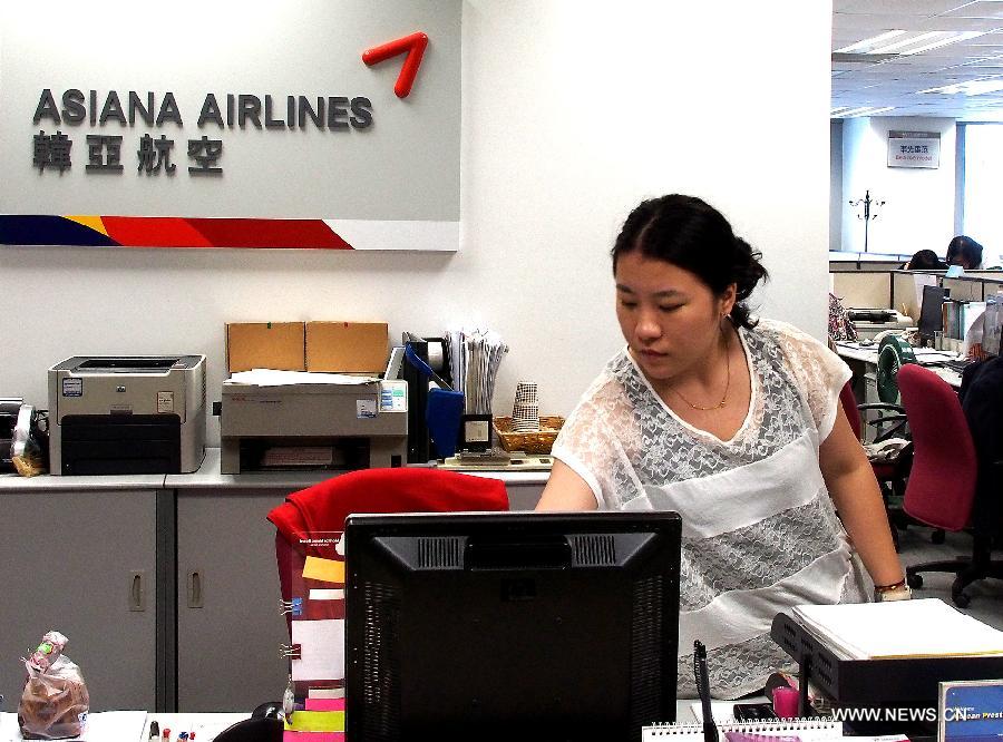 An employee works at the office of the Asiana Airlines to Shanghai, east China, July 7, 2013. A total of 141 Chinese citizens were among the 291 passengers aboard the Asiana Airlines flight that crash-landed at the San Francisco International Airport on Saturday, and 90 of the Chinese passengers in total departed from Shanghai via Seoul to the San Francisco airport in the U.S. All the two killed in the crash were identified to be Chinese women, South Korea's transportation ministry said Sunday. (Xinhua/Chen Fei)  
