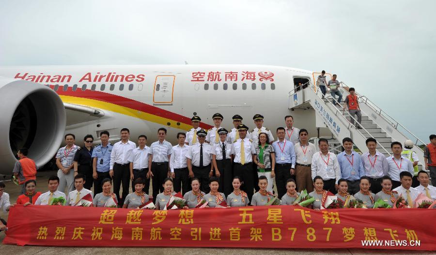 Crew members of the Haian Airlines pose for a group photo with a Boeing 787 Dreamliner at the Haikou Meilan International Airport in Haikou, capital of south China's island of Hainan Province, July 7, 2013. Haian Airlines held a ceremony here to welcome the arrival of its first Boeing 787 Dreamliner. Mou Wei, vice president of Hainan Airlines, said on July 4 that the first 213-seat Dreamliner will serve the domestic route between Beijing and Haikou, capital of south China's Hainan Province, with 36 seats reserved for business class and 177 for economy. (Xinhua/Zhao Yingquan) 