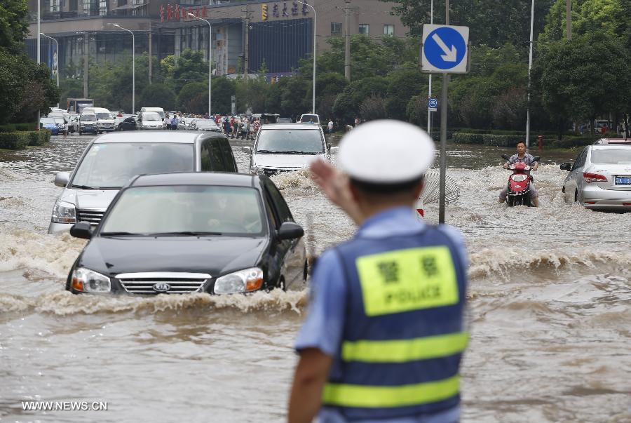 Cars move on a flooded road in Wuhan, capital of central China's Hubei Province, July 7, 2013. Wuhan was hit by the heaviest rainstorm in five years from Saturday to Sunday. The local meteorologic center has issued red alerts for rainstorm for many times in sequence. (Xinhua)
