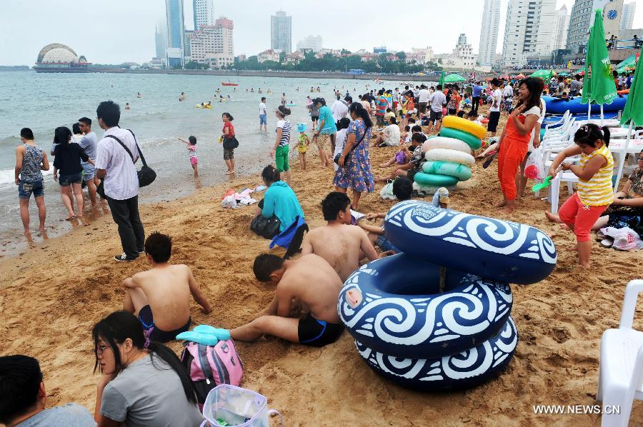 Tourists swarm a bathing beach in Qingdao, a coastal city of east China's Shandong Province, July 7, 2013. (Xinhua/Li Ziheng)
