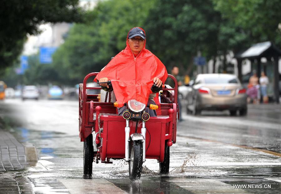 A man rides in rain cape in Yinchuan, capital of northwest China's Ningxia Hui Autonomous Region, July 7, 2013. Xiaoshu (Lesser Heat), the 11th of the 24 solar terms in the Chinese Lunar Calendar which means the beginning of hot summer, fell on Saturday. Rainfall brought cool to Yinchuan on Xiaoshu. (Xinhua/Peng Zhaozhi)