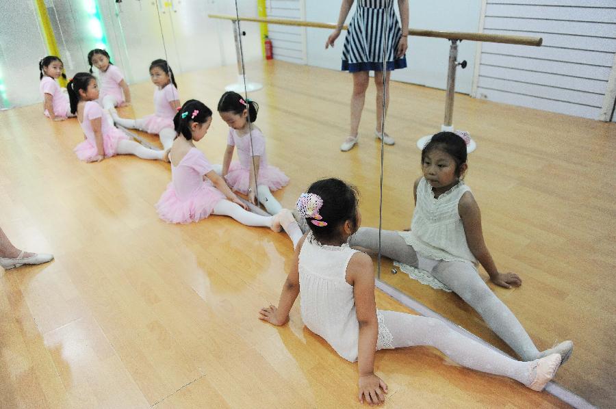 Young girls do physical training at a dance class during the summer vacation in Shanghai, east China, July 7, 2013. (Xinhua/Lai Xinlin) 