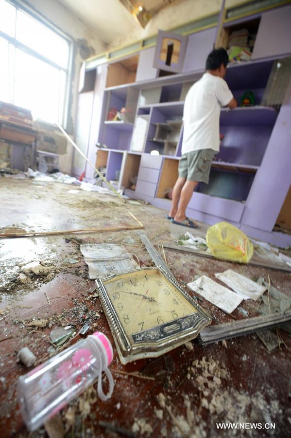 A villager cleans up his house damged by a tornado in Yuhu Village, Gaoyou City, east China's Jiangsu Province, July 8, 2013. Tornados battered Gaoyou and Yizheng in the province on July 7, making houses and power devices damaged. (Xinhua/Meng Delong)