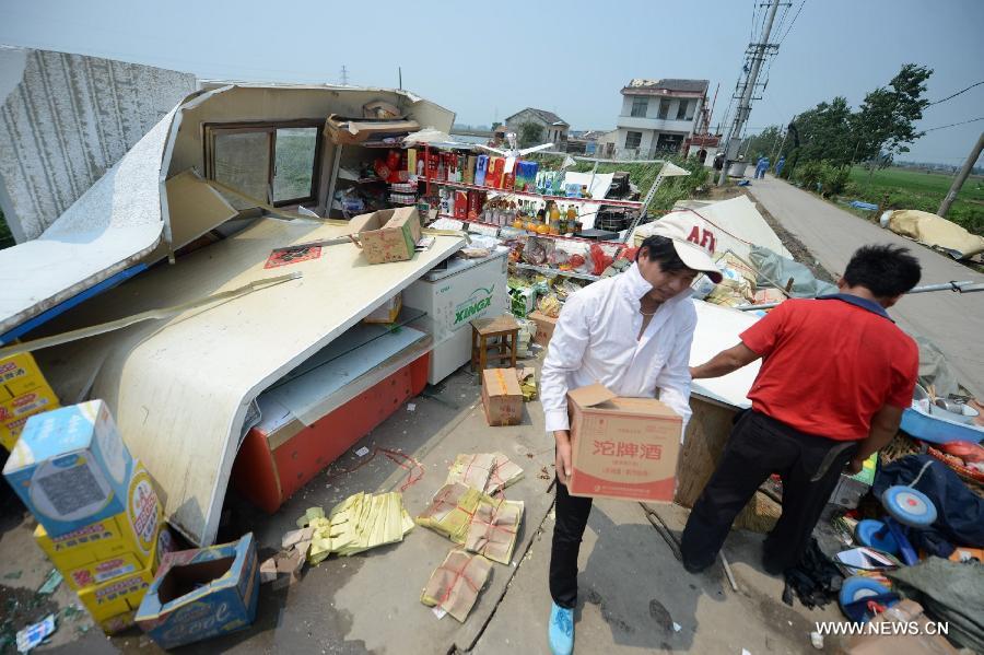 People salvage goods from a retail shop which collapsed in a tornado in Yuhu Village, Gaoyou City, east China's Jiangsu Province, July 8, 2013. Tornados battered Gaoyou and Yizheng in the province on July 7, making houses and power devices damaged. (Xinhua/Meng Delong)