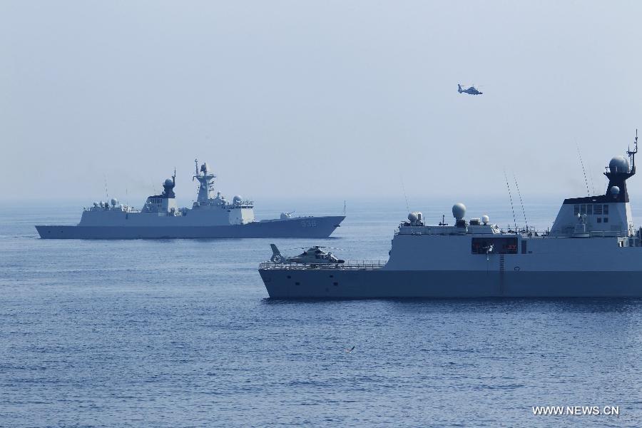Chinese naval ships and a ship-borne helicopter attend the "Joint Sea-2013" drill at Peter the Great Bay in Russia, July 9, 2013. Chinese and Russian warships carried out a variety of exercises including joint air defense, maritime supply, joint escort and the rescue of hijacked vessels during the second day of "Joint Sea-2013" drill. (Xinhua/Zha Chunming) 
