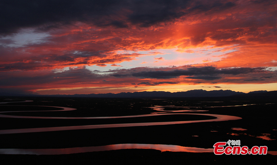 The sky turns red at sunset over the Bayanbulak Grassland in Hejing County, Northwest China's Xinjiang Uygur Autonomous Region. The Bayanbulak Grassland is a great prairie boasting luxuriant verdant grass, numerous flocks of sheep and varied plants, making it the second largest grassland in China. (CNS)