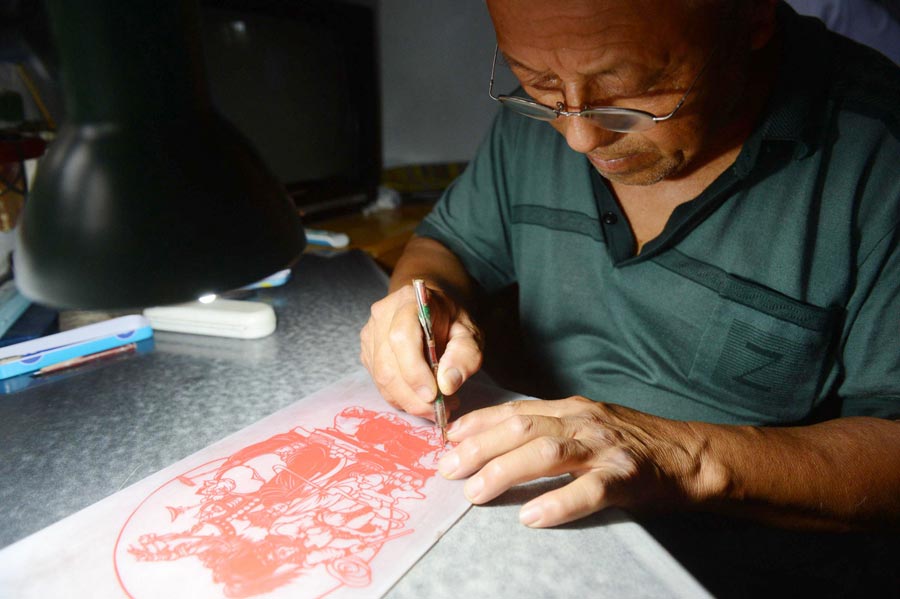 Li Xiangkui, 65, creates his paper-cut work from characters out of the book "Journey to the West" in Cangzhou, Hebei province, July 7, 2013. (Photo/Xinhua)