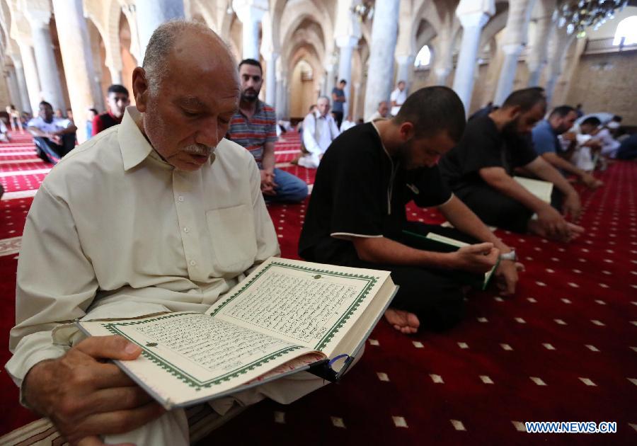Libyan men read the Koran in a mosque in Tripoli, capital of Libya, on July 10, 2013, the first day of the holy month of Ramadan.(Xinhua/Hamza Turkia)