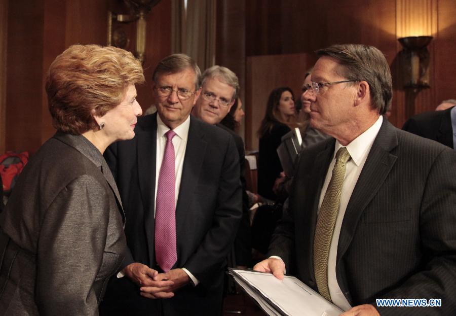 Smithfield Foods CEO Larry Pope (R) talks with Chairwoman of the Senate Committee on Agriculture, Nutrition and Forestry Debbie Stabenow after a hearing on the purchase of Smithfield in Washington, the United States, July 10, 2013. Smithfield Foods CEO Larry Pope on Wednesday tried to relieve senators' concerns over Chinese Shuanghui International Holdings Ltd.'s purchase of his company. (Xinhua/Wang Zongkai)