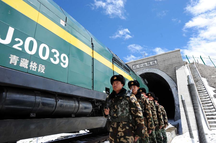 Armed policemen patrol along the Qinghai-Tibet Railway at the 1,686-meter Kunlun Mountain Tunnel in northwest China's Qinghai Province, July 9, 2013. The armed policemen overcome the harsh climate and lack of oxygen, and stick to their post. (Xinhua/Hou Deqiang)