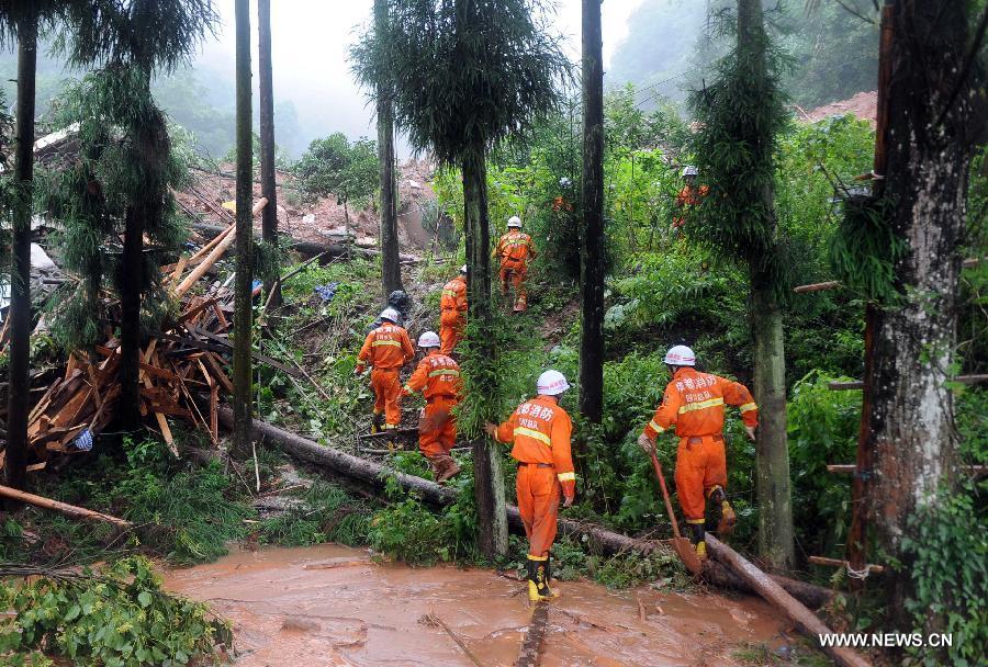 Fire fighters walk on muds while searching for survivors at the Sanxi Village, in Dujiangyan City, southwest China's Sichuan Province, July 11, 2013. As of 2:10 p.m. Thursday, rescuers had found 18 bodies from the landslide that happened on Wednesday morning in the village of Sanxi. (Xinhua/Xue Yubin)