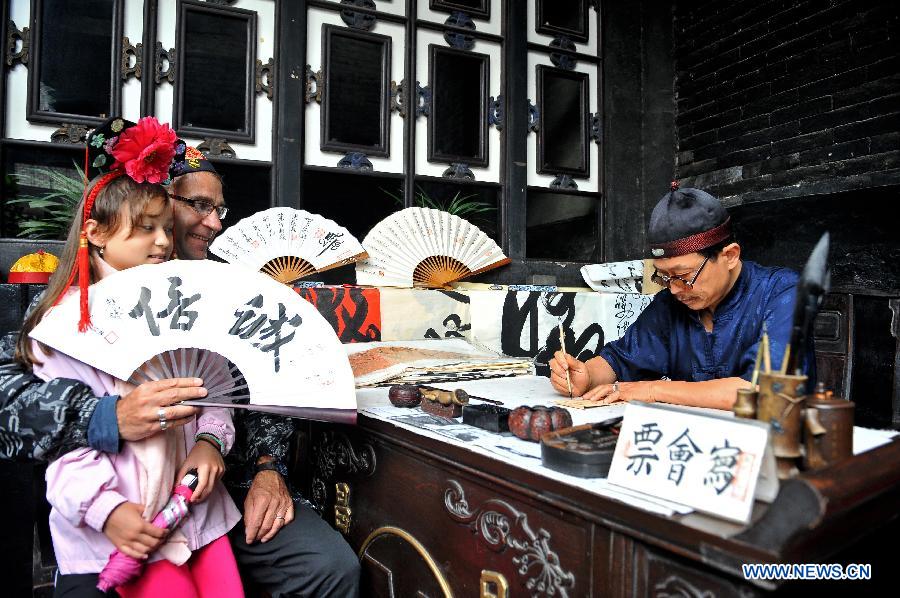 Jia Weixing, a man aged 55, writes a "huipiao", or a voucher to draw money from a bank in another place in ancient times, at China Piaohao (a bank in ancient China) Museum in Pingyao County, north China's Shanxi Province, July 11, 2013. No matter whether they are natives, migrators or tourists, they have their own stories in this ancient town. (Xinghua/He Canling)