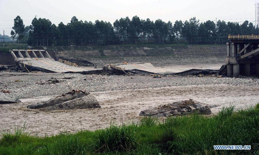 Photo taken on July 11, 2013 shows the collapsed Chuanxi Bridge in Junyue Town of Pengzhou City, southwest China's Sichuan Province. Rainstorms battered the region these days, and the fast flow of the river water brought damages to the bridge. The damages had been found in time and the traffic had been controlled. No casualties were reported in the accident. (Xinhua/Yu Ping)