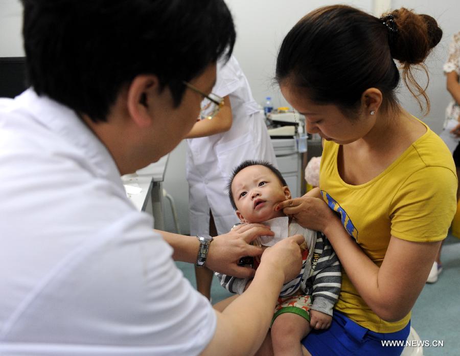 A doctor applies herb sticks to accupuncture points in hot summer days onto a baby at the First Affiliated Hospital of Henan University of Traditional Chinese Medicine in Zhengzhou, capital of central China's Henan Province, July 13, 2013. Saturday marks the beginning of the hottest part of summer. Many people go to their local hospitals of traditional Chinese medicine to apply herb sticks to accupuncture points to prevent diseases. (Xinhua/Li Bo)