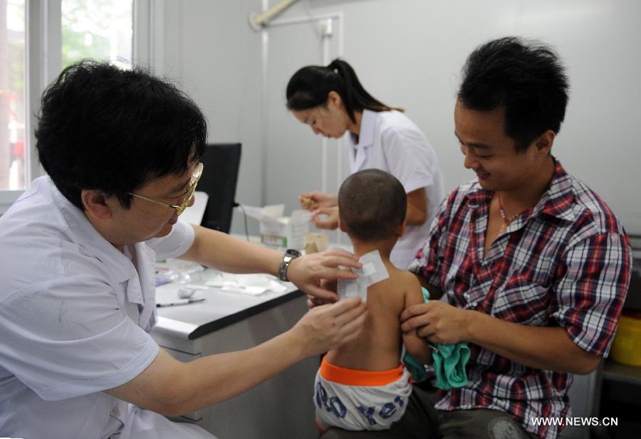 A doctor applies herb sticks to accupuncture points in hot summer days onto the back of a boy at the First Affiliated Hospital of Henan University of Traditional Chinese Medicine in Zhengzhou, capital of central China's Henan Province, July 13, 2013. Saturday marks the beginning of the hottest part of summer. Many people go to their local hospitals of traditional Chinese medicine to apply herb sticks to accupuncture points to prevent diseases. (Xinhua/Li Bo)