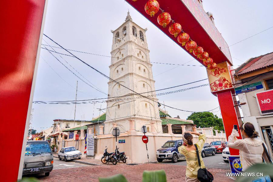 Tourists visit an ancient mosque which was built by Indians in the early 18th century in Melaka, Malaysia, on July 12, 2013. Melaka and George Town, historic cities of the Straits of Malacca, were inscribed onto the list of UNESCO World Heritage Site in July 2008. (Xinhua/Chong Voon Chung)