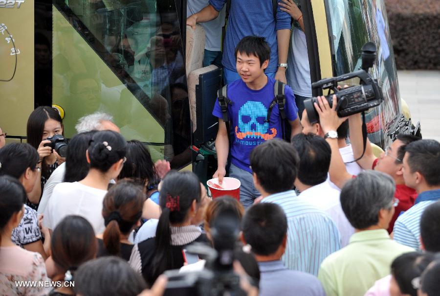 A student gets off the bus as he arrives at Jiangshan Middle School in Jiangshan, east China's Zhejiang province, July 14, 2013. A total of 31 students and teachers who were held up in the U.S. by the crashed Asiana Airlines Flight 214 at the San Francisco International Airport returned to Beijing on Saturday and reached home on Sunday. Two Chinese girls were killed on the spot during the crash on July 6. Another girl died on July 12 after succumbing to injuries. (Xinhua/Wang Dingchang)