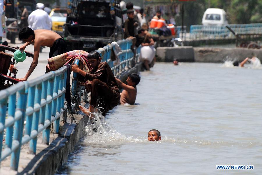 Pakistani children cool off in a river canal during heat wave in northwest Pakistan's Peshawar on July 14, 2013. Temperatures reached over 40 degrees Celsius in many parts of the country Sunday. (Xinhua/Umar Qayyum)