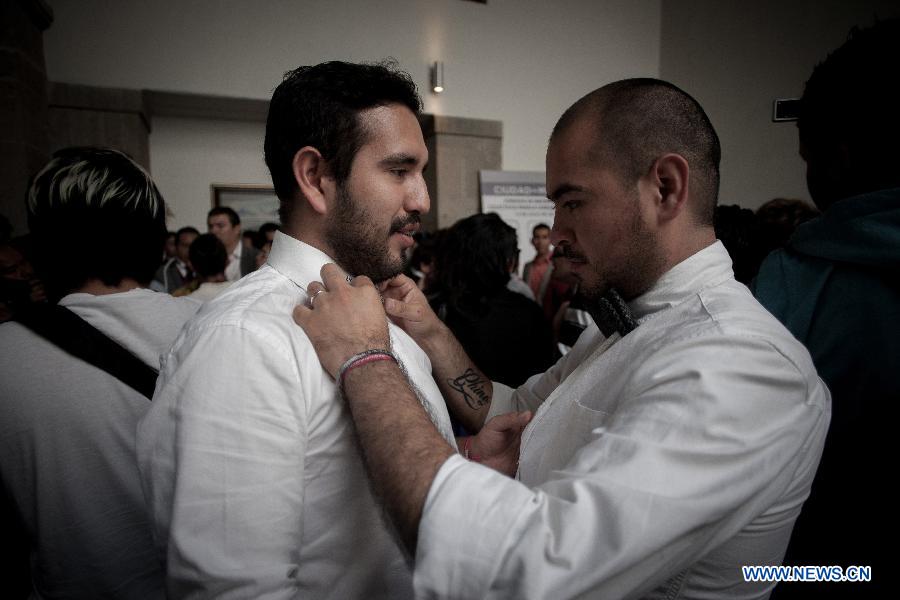 A same sex couple get ready for a collective gay wedding in Mexico City, capital of Mexico, on July 14, 2013. The collective gay wedding celebrated in Mexico's capital, was presided by Mexico's City Head of Government, Miguel Angel Mancera, according to the local press. (Xinhua/Pedro Mera)