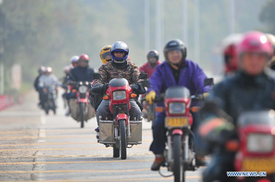 Migrant workers ride motorbikes on their way back home on the 321 National Highway in Wuzhou, south China's Guangxi Zhuang Autonomous Region, Jan. 29, 2013. Many Guangxi migrant workers working in south China's Guangdong Province got around the ticket buying predicament during the Spring Festival travel rush which lasts for forty days by riding back home thanks to the well-developed roads connecting Guangxi and Guangdong. (Xinhua/Huang Xiaobang) 