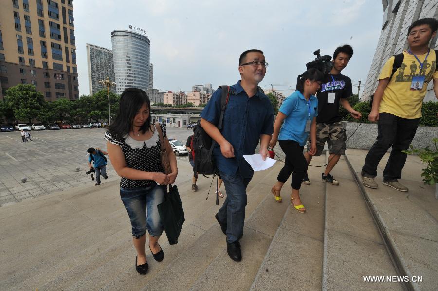Tang Hui (L 1st) , mother of a young rape victim who sued a local authority for putting her into a labor camp, walks into The Hunan Provincial People's High Court in Changsha, capital of central China's Hunan Province, July 15, 2013. The Hunan Provincial People's High Court on Monday ordered the Yongzhou municipal re-education through labor commission to pay Tang Hui 2,941 yuan (478 U.S. dollars) in compensation for infringing upon her personal freedom and causing mental damages. The 40-year-old mother appealed to the high court in April after the Yongzhou Intermediate People's Court denied her request for an apology and compensation from the re-education through labor commission. Tang was put into the labor camp after she publicly petitioned for harsher punishments for those found guilty of raping her daughter and forcing her into prostitution. (Xinhua/Long Hongtao)